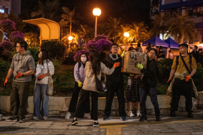 volunteers-in-a-human-chain-moving-boxes-of-supplies-near-the-scene-of-where-a-major-fire-engulfed-several-residential-buildings-at-wang-fuk-court-on-november-28-2025-in-hong-kong-photo-by-vernon-y
