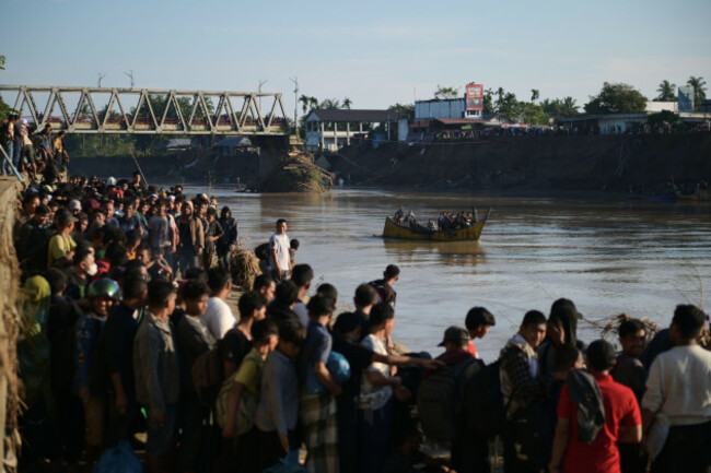 people-wait-for-a-boat-to-ride-across-a-river-after-a-bridge-nearby-collapsed-during-a-flood-in-bireun-aceh-province-indonesia-saturday-nov-29-2025-ap-photoreza-saifullah