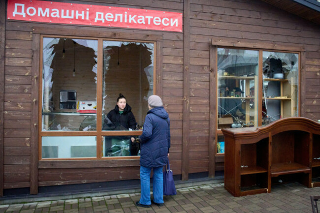an-owner-of-a-small-private-shop-homemade-delicacies-is-seen-through-the-broken-window-speaking-with-a-customer-after-russias-night-missile-attack-on-a-residential-neighbourhood-in-vyshgorod-outsi