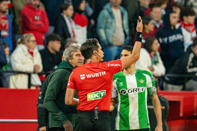 sevilla-spain-30th-nov-2025-referee-jose-luis-munuera-montero-talk-to-coaches-head-coach-manuel-pellegrini-real-betis-captain-marc-bartra-n5-before-suspending-the-game-due-to-sevilla-fc-fans-th