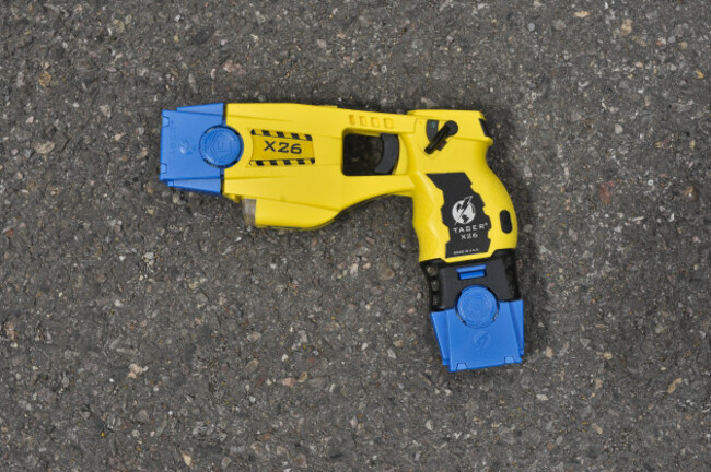 a-taser-x26-fitted-with-two-blue-training-cartriges-areas-that-can-be-seen-are-the-firing-end-pictured-left-white-torch-light-and-laser-sight-pictured-underneath-the-blue-cartridge-trigger-pic
