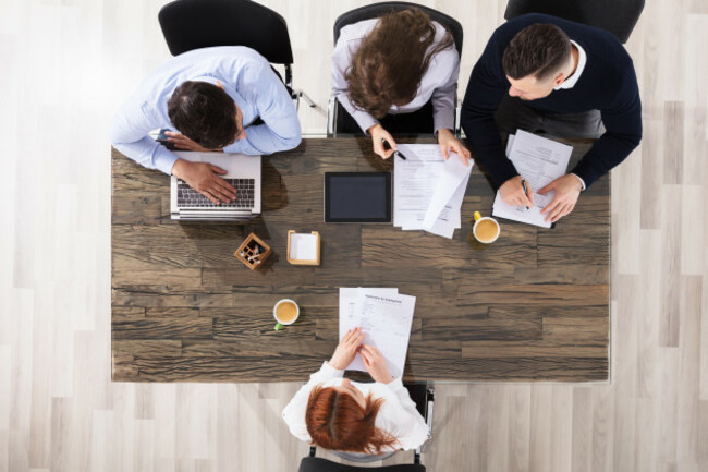 group-of-corporate-recruitment-officers-interviewing-a-woman-in-office