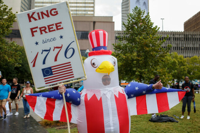 dallas-texas-usa-18th-oct-2025-a-participant-dressed-as-a-bald-eagle-holds-a-sign-during-the-no-kings-protest-at-pacific-plaza-in-downtown-dallas-texas-on-saturday-the-protest-part-of-a-nationw