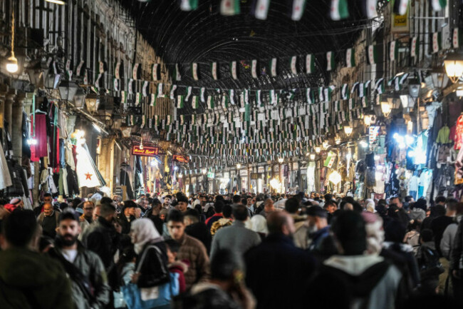 damscus-syria-06th-dec-2025-people-walk-through-elhamedya-market-in-damascus-which-is-decorated-by-flags-marking-the-first-anniversary-of-the-fall-of-assad-syria-is-approaching-the-first-anniver