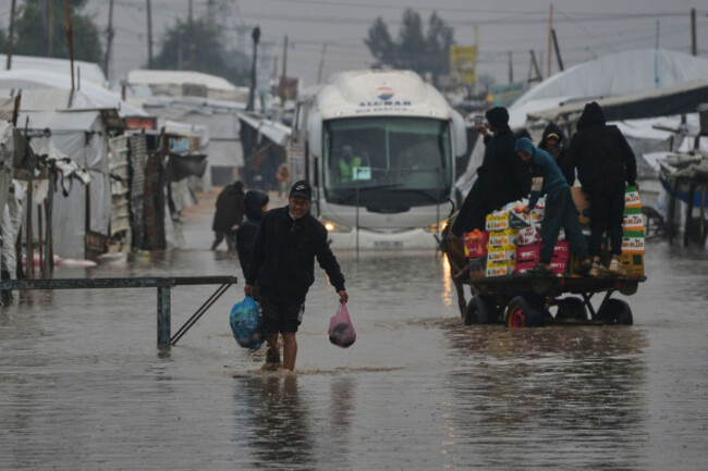 palestinians-walk-through-a-flooded-street-following-heavy-rain-in-khan-younis-southern-gaza-strip-thursday-dec-11-2025-ap-photoabdel-kareem-hana