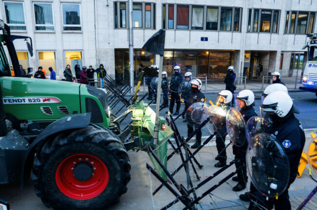 police-guard-a-barrier-as-farmers-drive-their-tractors-to-block-a-main-boulevard-during-a-demonstration-outside-a-gathering-of-european-leaders-at-the-eu-summit-in-brussels-thursday-dec-18-2025