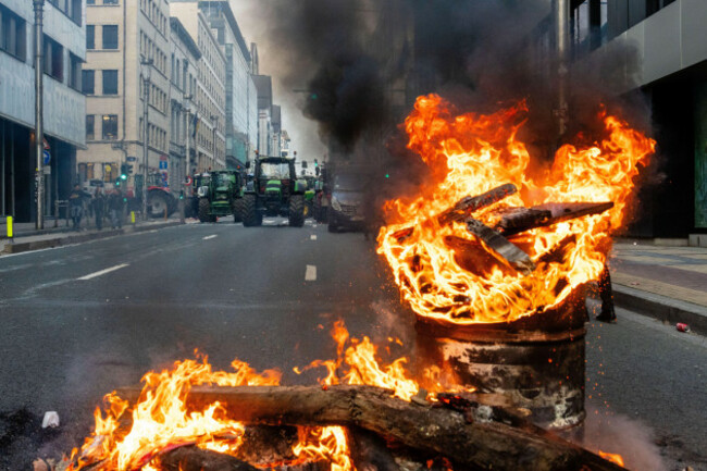 a-fire-burns-in-a-barrel-as-european-farmers-block-a-road-with-their-tractors-during-a-demonstration-outside-the-eu-summit-in-brussels-thursday-dec-18-2025-ap-photomarius-burgelman