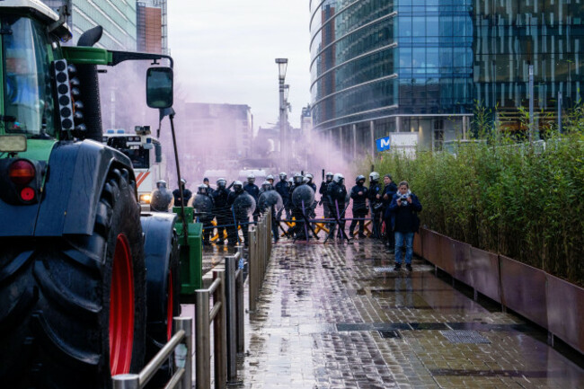 police-stand-behind-a-barrier-as-european-farmers-block-a-road-with-their-tractors-during-a-demonstration-outside-the-eu-summit-in-brussels-thursday-dec-18-2025-ap-photomarius-burgelman