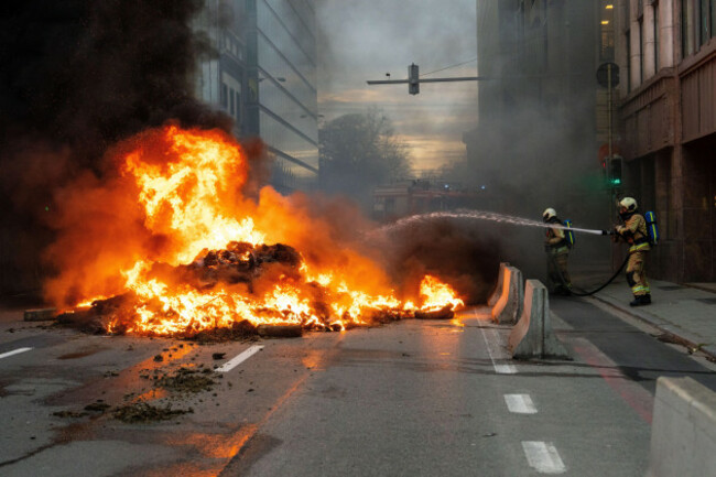 firemen-extinguish-a-fire-set-by-protestors-during-a-demonstration-of-european-farmers-near-the-european-parliament-in-brussels-thursday-dec-18-2025-ap-photomarius-burgelman