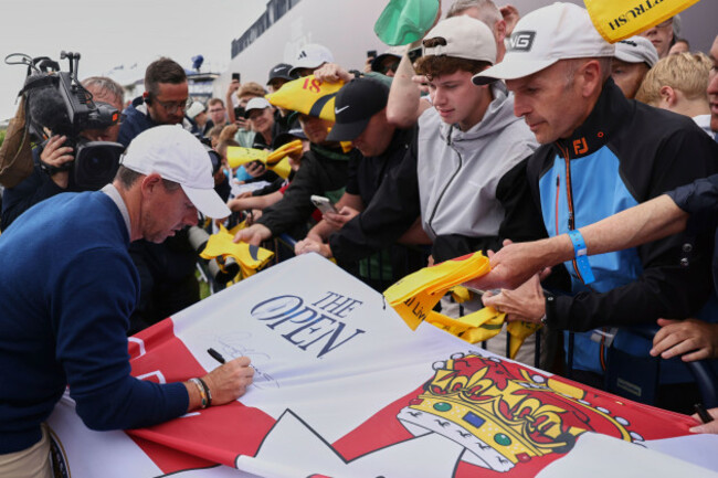 rory-mcilroy-of-northern-ireland-signs-a-replica-northern-ireland-flag-on-the-18th-green-following-a-practice-round-for-the-2025-british-open-golf-championship-at-the-royal-portrush-golf-club-norther