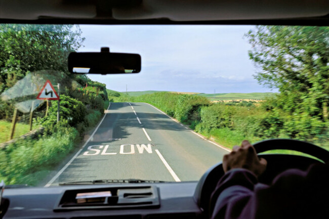 view-from-a-car-of-a-road-marked-with-the-word-slow-and-the-surrounding-english-countryside-great-britain