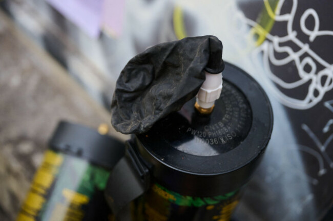 berlin-germany-12th-nov-2025-two-used-nitrous-oxide-bottles-and-a-used-balloon-are-on-a-windowsill-in-front-of-a-late-night-shop-on-november-13-the-bundestag-votes-on-a-planned-ban-on-nitrous-ox