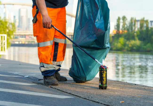 02-may-2025-hesse-frankfurtmain-the-employee-of-a-municipal-waste-disposal-company-removes-the-remains-of-the-previous-night-including-a-nitrous-oxide-bottle-on-the-banks-of-the-main-in-the-rowi