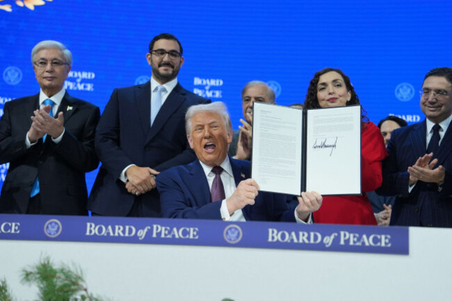 president-donald-trump-center-holds-up-a-signed-board-of-peace-charter-during-the-annual-meeting-of-the-world-economic-forum-in-davos-switzerland-thursday-jan-22-2026-ap-photoevan-vucci