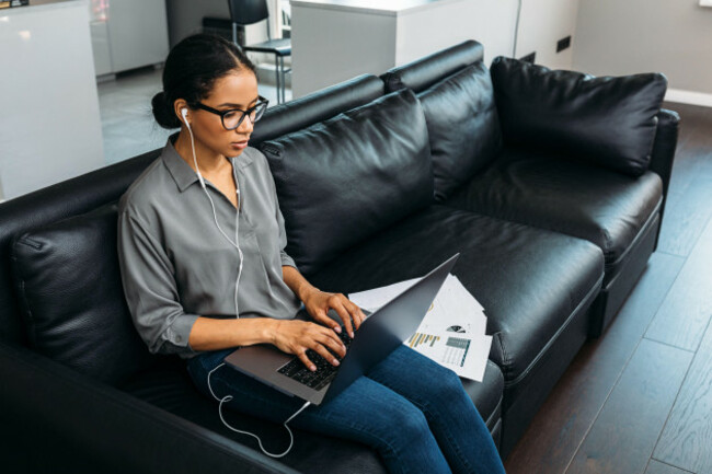 young-woman-working-at-home-with-laptop-and-documents-businesswoman-working-from-home