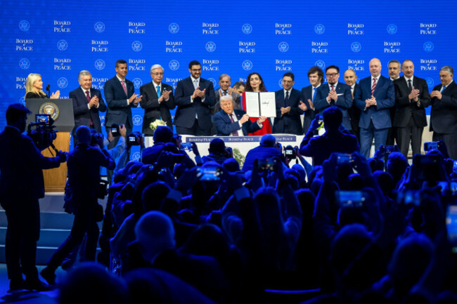 president-donald-trump-center-holds-up-a-signed-board-of-peace-charter-during-the-annual-meeting-of-the-world-economic-forum-in-davos-switzerland-thursday-jan-22-2026-gian-ehrenzellerkeyston