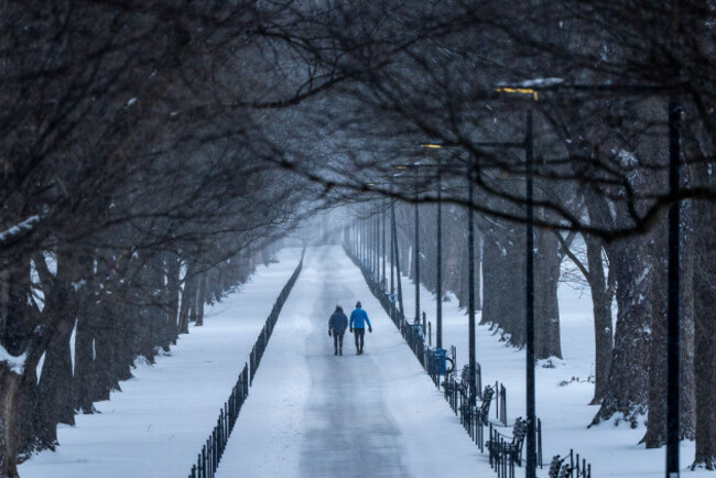 two-people-walk-along-the-national-mall-as-snow-falls-sunday-jan-25-2026-in-washington-ap-photoalex-brandon