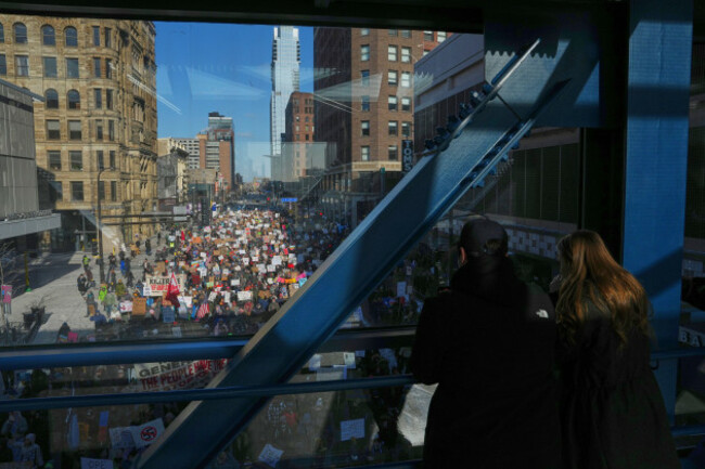 people-stand-on-a-bridge-while-watching-a-protest-against-ice-immigration-and-customs-enforcement-in-downtown-minneapolis-sunday-jan-25-2026-ap-photoadam-gray