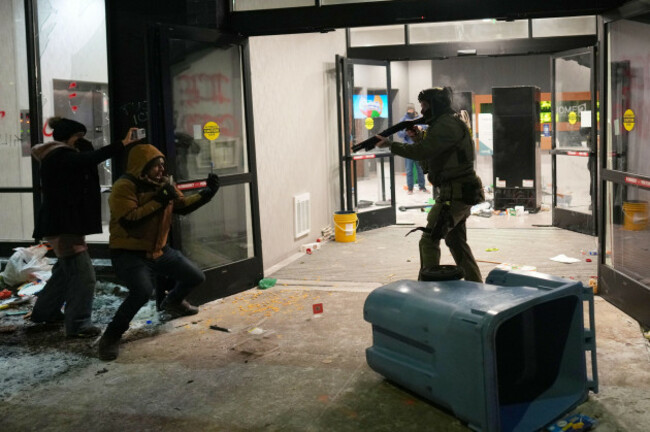 a-federal-agent-points-a-weapon-at-a-person-outside-a-hotel-during-a-noise-demonstration-protest-in-response-to-federal-immigration-enforcement-operations-in-the-city-sunday-jan-25-2026-in-minneap