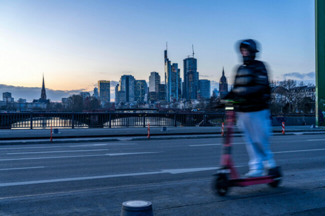 skyline-of-the-city-center-of-frankfurt-am-main-e-scooter-on-the-raft-bridge-dusk-river-main-winter-hesse-germany