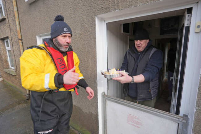volunteer-shane-oconnor-from-slaney-search-and-rescue-delivers-for-and-water-to-island-road-resident-mick-oneill-in-enniscorthy-co-wexford-after-storm-chandra-hit-the-island-of-ireland-picture-date