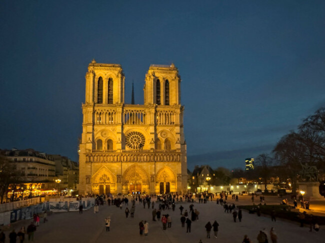 night-shot-of-notre-dame-cathedral-with-crowd-paris-france