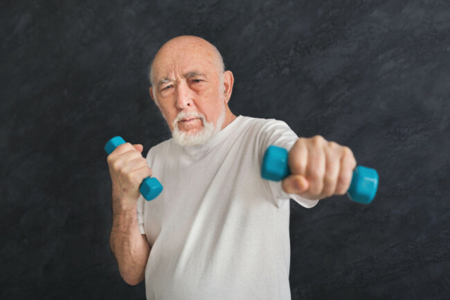 senior-man-exercising-with-dumbbells-in-a-home-gym-during-a-morning-workout-session