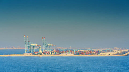 manama-bahrain-jan-08-2024-panoramic-view-of-bahrain-commercial-international-port-with-blue-cranes-pier-buildings-and-containers-with-sea-on