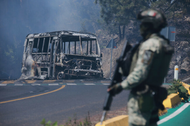 file-a-soldier-stands-guard-by-a-charred-vehicle-after-it-was-set-on-fire-in-cointzio-mexico-feb-22-2026-following-the-death-of-the-leader-of-the-jalisco-new-generation-cartel-nemesio-oseguer