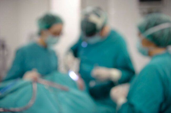three-blurred-doctors-performing-surgery-in-hospital-operating-room