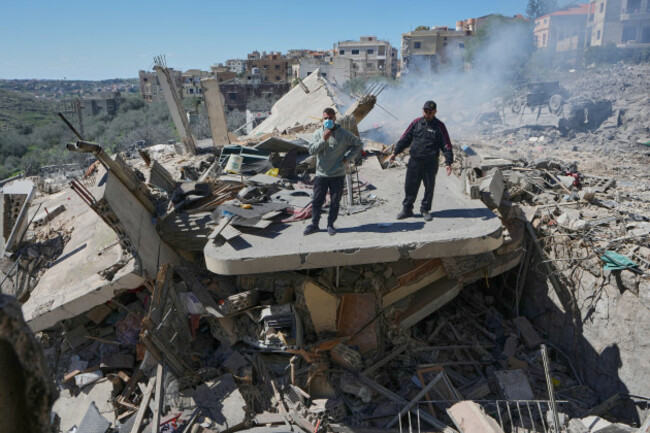 people-stand-on-the-wreckage-of-destroyed-houses-that-were-hit-by-israeli-airstrikes-in-sir-al-gharbiyeh-village-south-lebanon-sunday-march-8-2026-ap-photomohammed-zaatari
