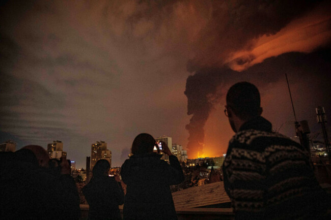 residents-look-on-and-take-pictures-as-flames-and-smoke-rise-from-an-oil-storage-facility-struck-as-attacks-hit-the-city-during-the-u-s-israeli-military-campaign-in-tehran-iran-saturday-march-7-2