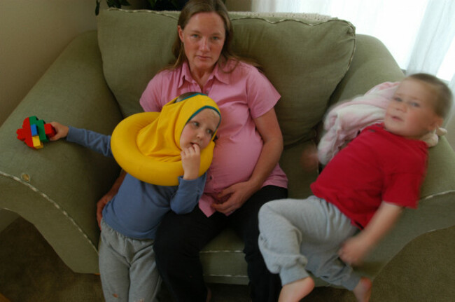 pregnant-tired-twentysomething-mother-with-3-children-playing-at-home-on-the-sofa