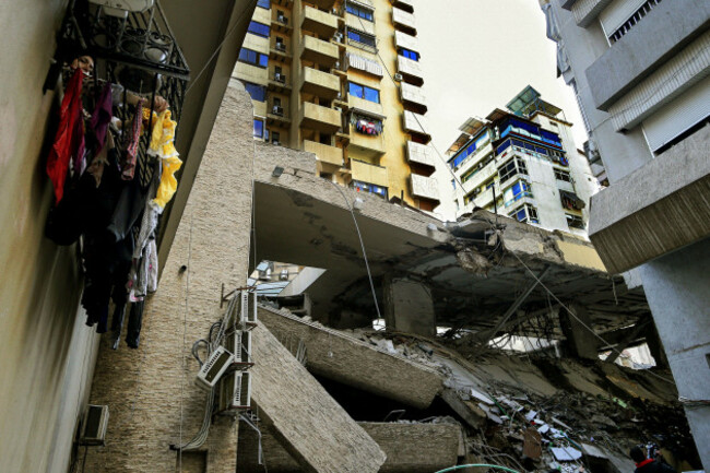 beirut-beirut-lebanon-13th-mar-2026-a-woman-hangs-laundry-on-her-balcony-adjacent-to-the-qard-al-hassan-building-the-financial-institution-of-pro-iranian-hezbollah-that-was-targeted-by-an-israel