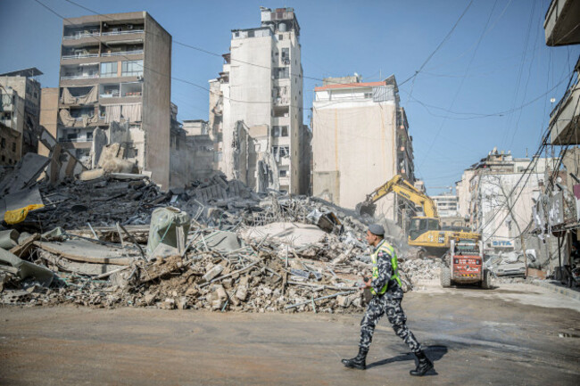 beirut-lebanon-19th-mar-2026-a-policeman-walks-past-the-remains-of-a-building-in-bachoura-which-was-hit-by-an-israeli-airstrike-at-least-886-people-have-been-killed-according-to-lebanons-minis