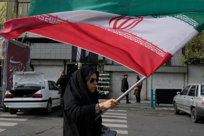 a-woman-waves-an-iranian-flag-during-a-campaign-in-support-of-the-government-at-the-enqelab-e-eslami-or-islamic-revolution-square-in-downtown-tehran-iran-sunday-march-22-2026-ap-photovahid-sa