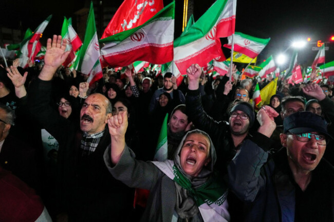 pro-government-supporters-chant-slogans-and-wave-iranian-flags-during-a-rally-in-a-square-in-western-tehran-iran-wednesday-march-25-2026-ap-photovahid-salemi