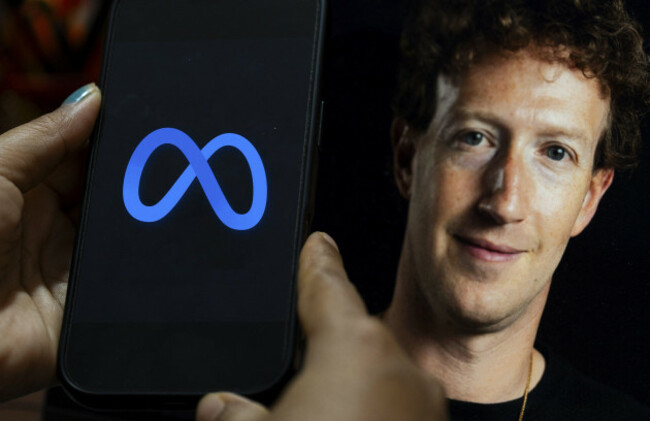 in-this-photo-illustration-a-smartphone-displays-the-meta-logo-on-its-screen-with-an-image-of-meta-ceo-mark-zuckerberg-visible-in-the-background-in