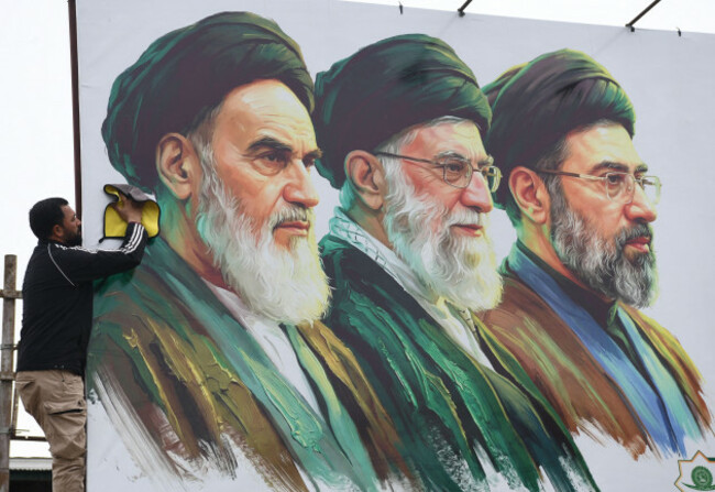 srinagar-jammu-and-kashmir-india-23rd-mar-2026-a-man-cleans-a-portrait-of-irans-late-supreme-leader-ruhollah-khomeini-l-late-supreme-leader-ayatollah-ali-khameneim-and-newly-elected-mojtaba
