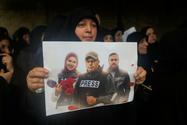 a-woman-holds-a-poster-showing-hezbollahs-al-manar-tv-correspondent-ali-shoeib-center-al-mayadeen-tv-reporter-fatima-ftouni-left-and-cameraman-ali-ftouni-during-their-funeral-at-a-temporary-cemet