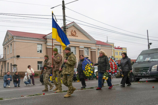 a-funeral-procession-for-20-year-old-volunteer-soldier-dmytro-dukhota-who-was-killed-in-a-battle-against-russian-troops-marches-down-the-street-strewn-with-flowers-in-the-village-of-novi-petrivtsi-c