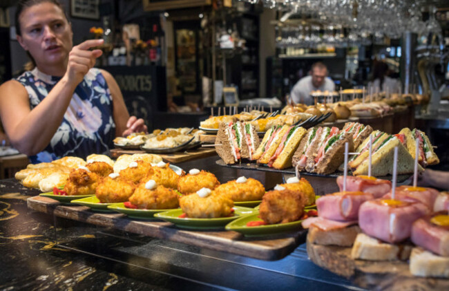 woman-choosing-pintxos-in-victor-montes-restaurant-8-plaza-nueva-or-8-plaza-berria-bilbao-espana
