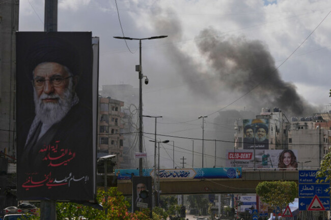 a-portrait-of-irans-late-supreme-leader-ayatollah-ali-khamenei-left-is-seen-as-smoke-rises-following-an-israeli-airstrike-in-dahiyeh-beiruts-southern-suburbs-lebanon-monday-march-30-2026-a
