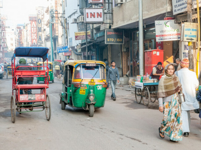traditional-rickshaw-and-tuktuk-on-a-street-in-new-dehli-the-green-and-yellow-tuktuks-are-iconic-for-dehli