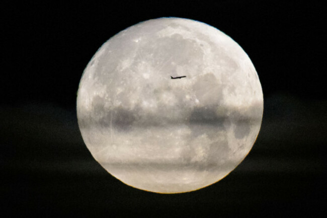 kennedy-space-center-united-states-of-america-01-april-2026-a-commercial-airliner-is-silhouetted-by-the-full-moon-as-the-nasa-artemis-ii-space-launch-system-rocket-with-the-orion-spacecraft-prepar