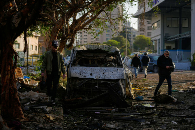 people-walk-past-a-damaged-vehicle-following-an-israeli-strike-in-beirut-lebanon-wednesday-april-1-2026-ap-photohassan-ammar