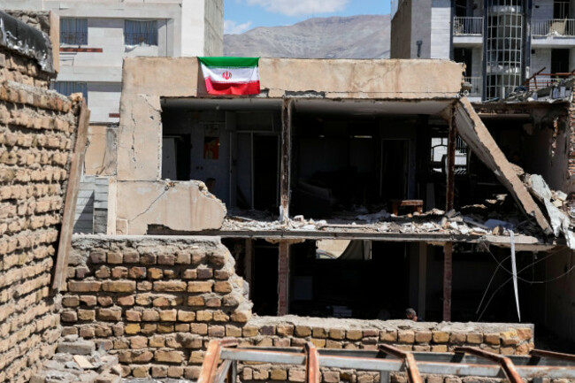 an-iranian-flag-hangs-from-the-roof-of-a-residential-building-damaged-by-recent-u-s-israeli-strikes-in-fardis-west-of-tehran-iran-friday-april-3-2026-ap-photovahid-salemi