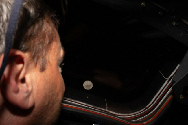 260406-washington-april-6-2026-xinhua-nasa-astronaut-reid-wiseman-looks-out-one-of-the-orion-spacecrafts-main-cabin-windows-at-the-moon-on-april-6-2026-the-crew-of-the-artemis-ii-missi