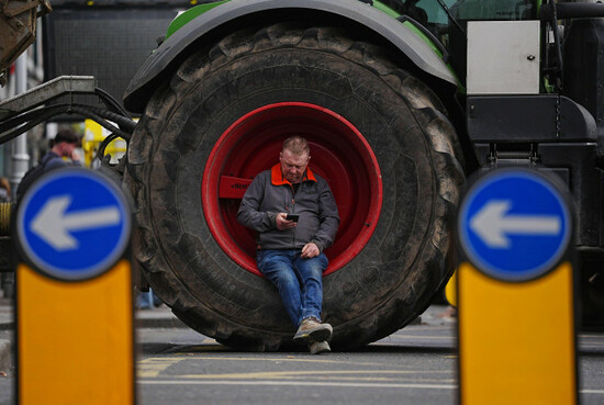 a-man-sits-in-a-tractor-wheel-as-vehicles-are-parked-on-oconnell-street-in-dublin-as-protestors-take-part-on-the-second-day-of-a-national-fuel-protest-against-rising-fuel-prices-demonstrators-drivin