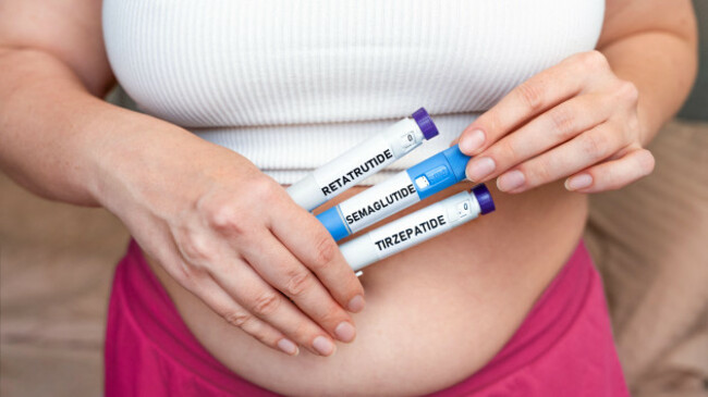 woman-holding-glp-1-injection-pens-semaglutide-tirzepatide-retatrutide-on-abdomen-weight-loss-and-diabetes-treatment-concept-close-up-with-copy